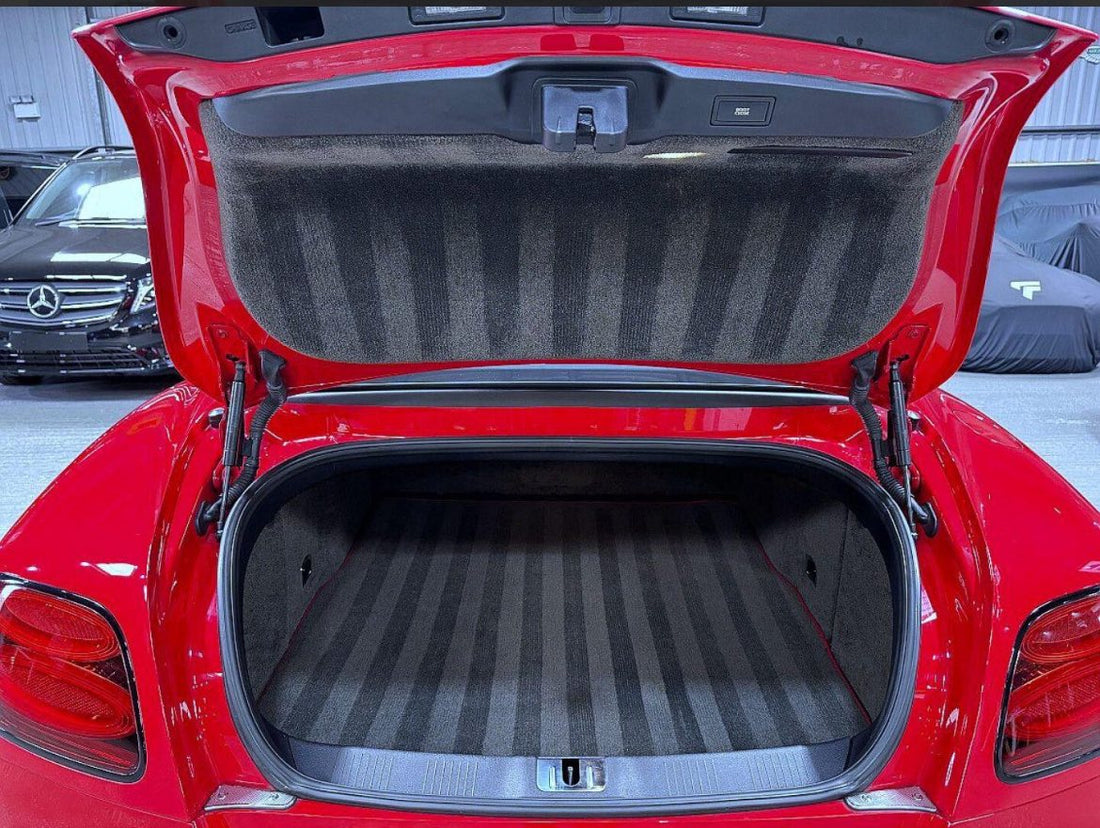 Professional luxury car interior detailing at FX Detailing Surrey. Close-up of deep-cleaned Alcantara and perforated leather seats in our Charlwood studio, featuring signature groomed carpet stripes.