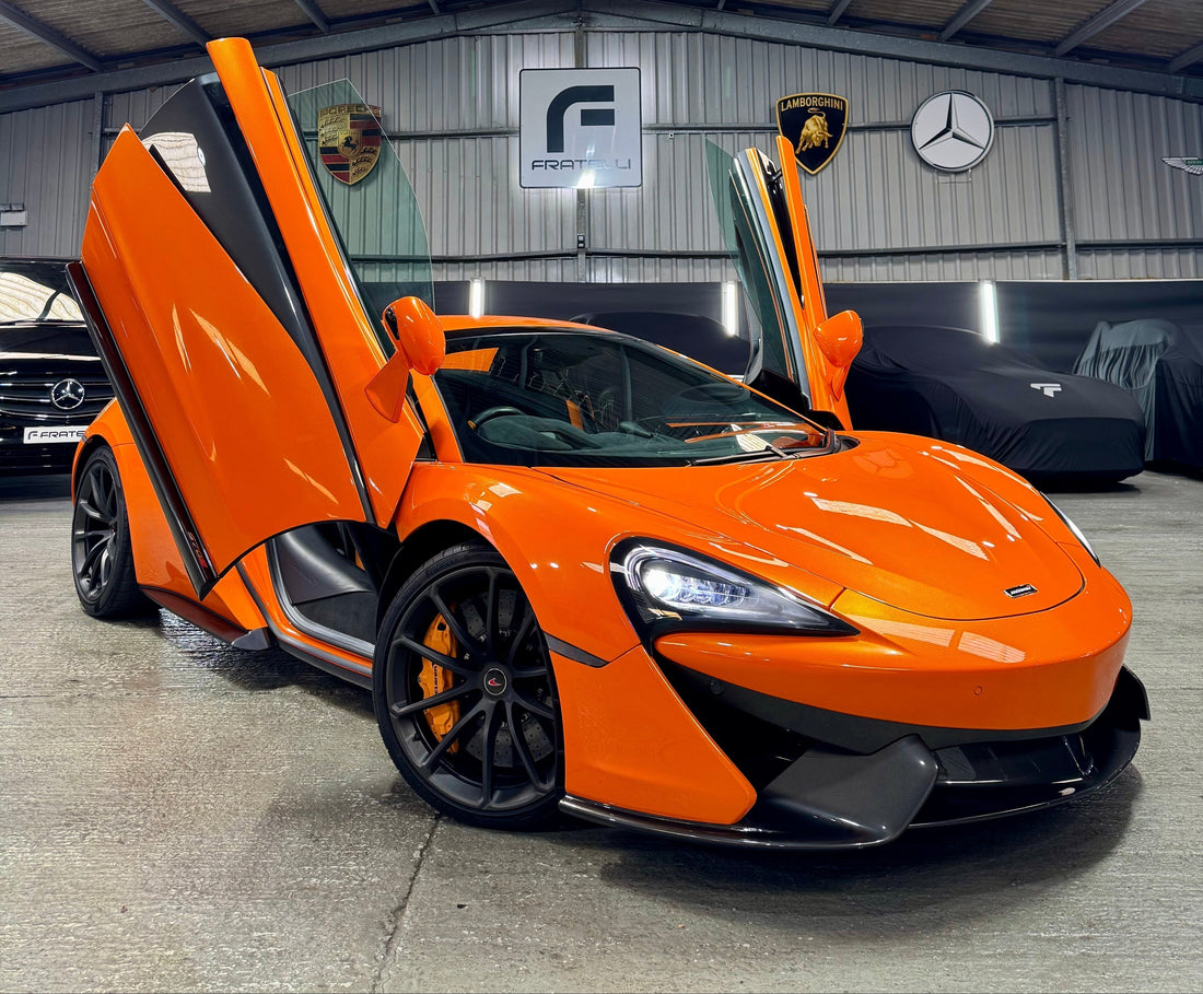 Full detailing and ceramic coating on a Volcano Orange McLaren 570S at FX Detailing Surrey. Image shows paint correction results on carbon fibre panels and Alcantara interior restoration in our Charlwood studio.
