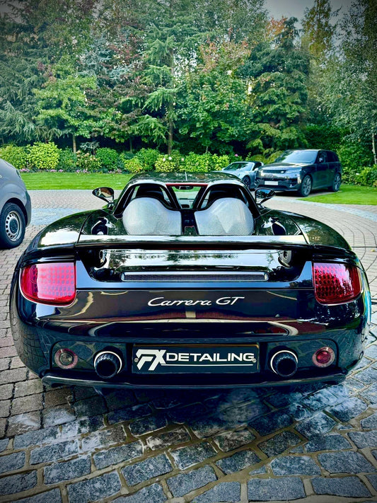 Full car detailing and ceramic coating on a Porsche Carrera GT at FX Detailing Surrey. High-gloss finish and paint correction on the carbon-fibre bodywork, showcasing absolute reflection and surface protection in our Charlwood studio.