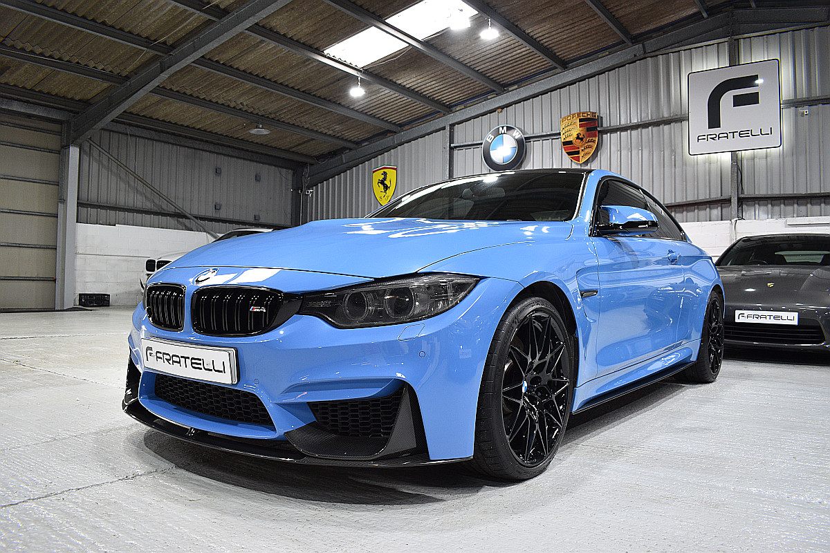 Light blue BMW M4 coupe with a front splitter and side skirt