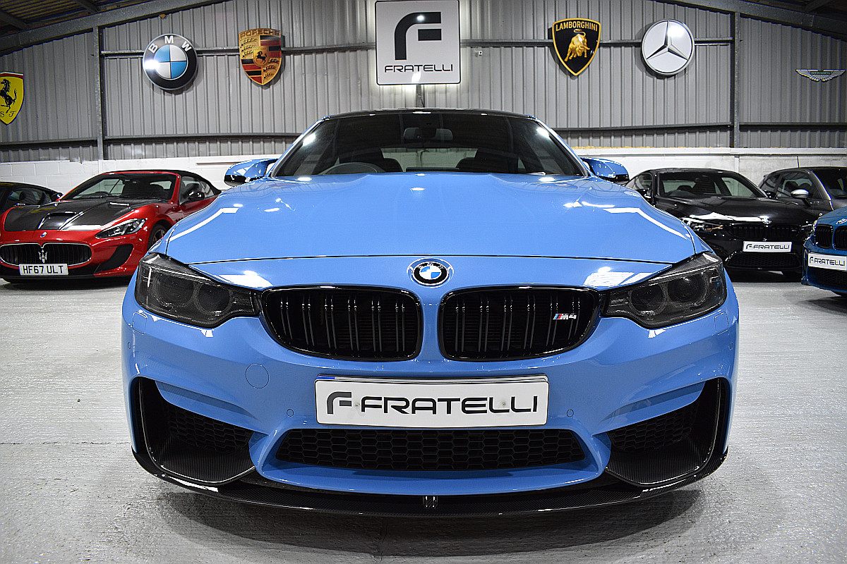 Front of a light blue BMW M4 with a carbon front splitter