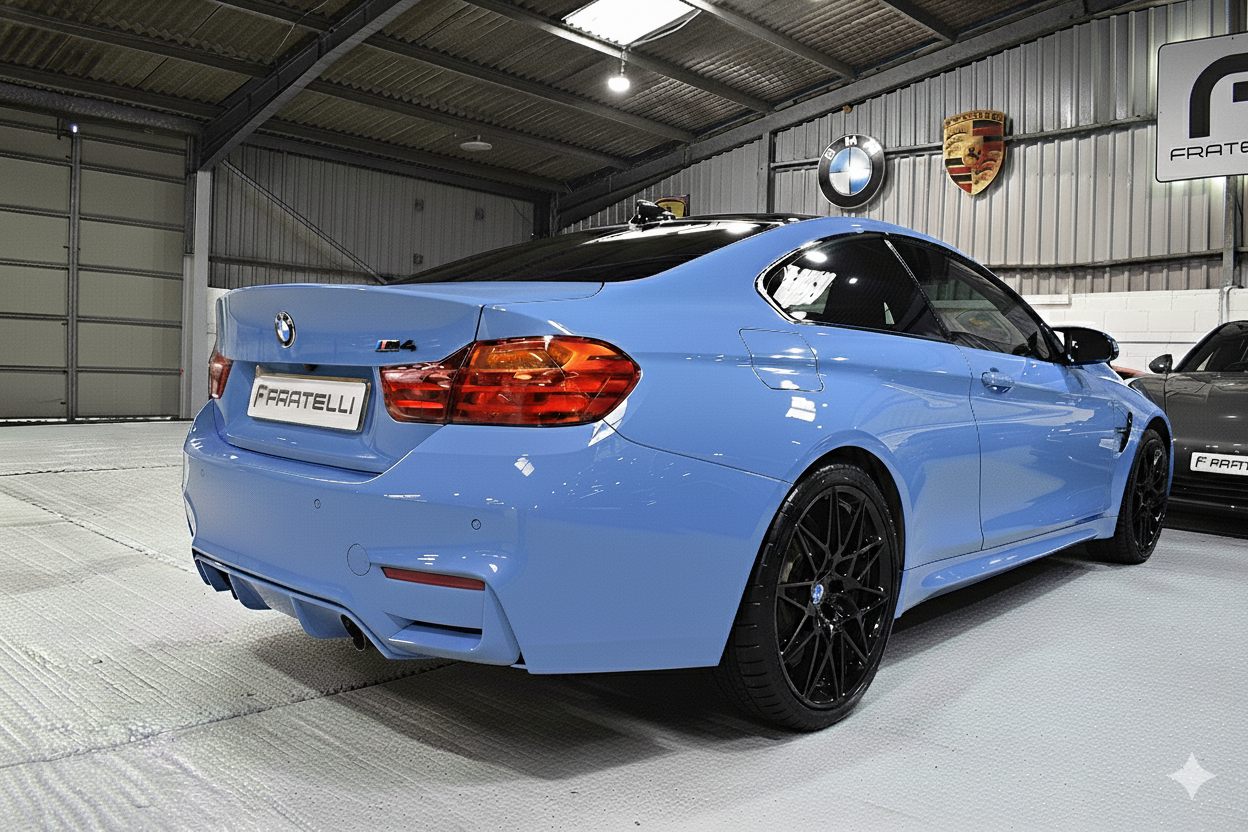 Rear three-quarter of a light blue BMW M4 before the spoiler, side skirt and diffuser