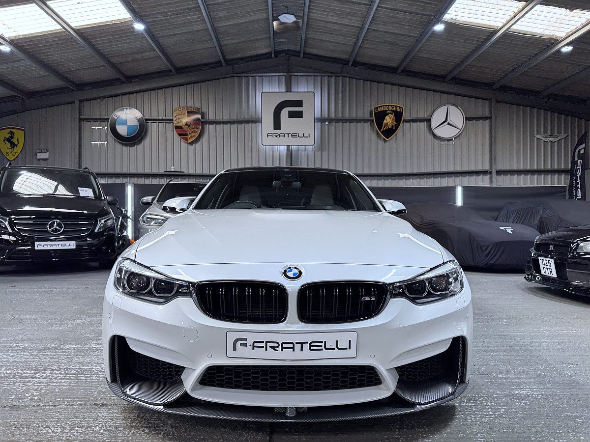 Front of a white BMW M3 saloon with a carbon front splitter