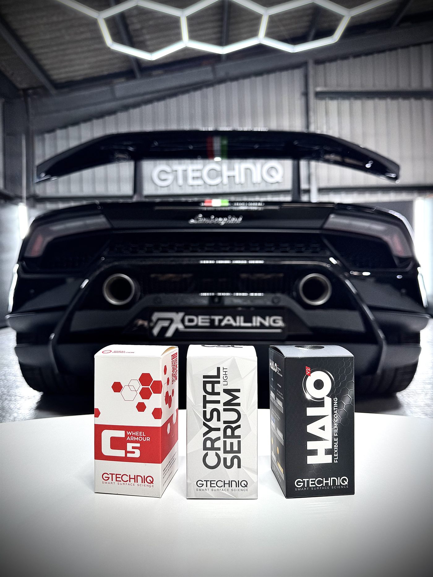 Gtechniq C5, Crystal Serum Light and Halo boxes in front of a black Lamborghini at FX Detailing