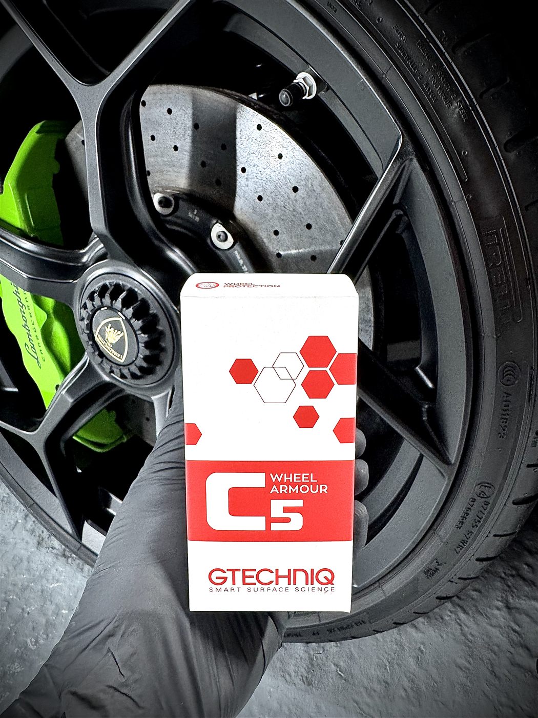 Gtechniq C5 Wheel Armour box held in front of a Lamborghini wheel