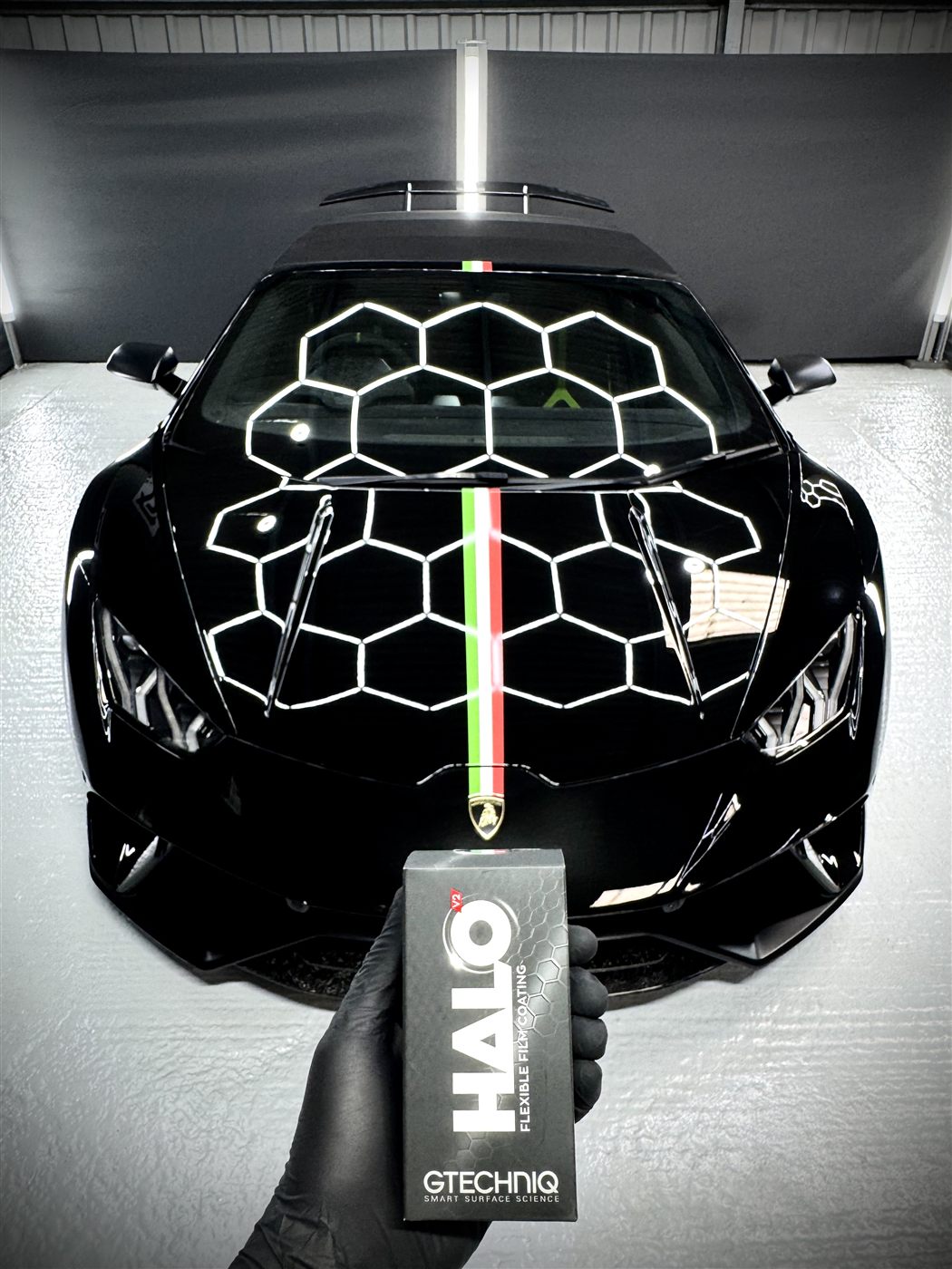 Gtechniq HALO flexible film coating held in front of a black Lamborghini