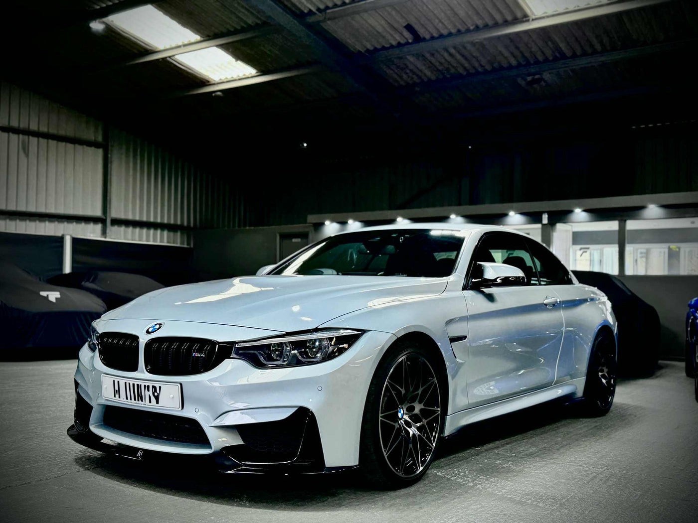 Professional BMW bodykit installation at FX Detailing Surrey. Image shows the 1 Series and M4 carbon fibre splitter fitment and pricing guide for our Charlwood studio.